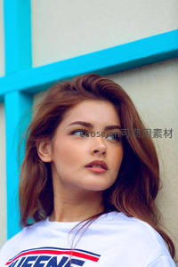 蓝墙前少女凝视远方沉思