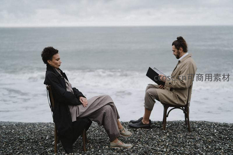 海边对坐沉思的两人