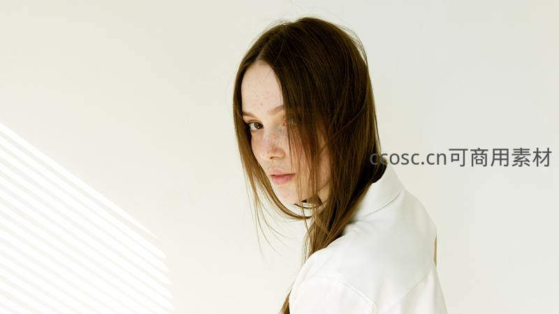 白衬衫少女回眸，光影温柔洒落肩头