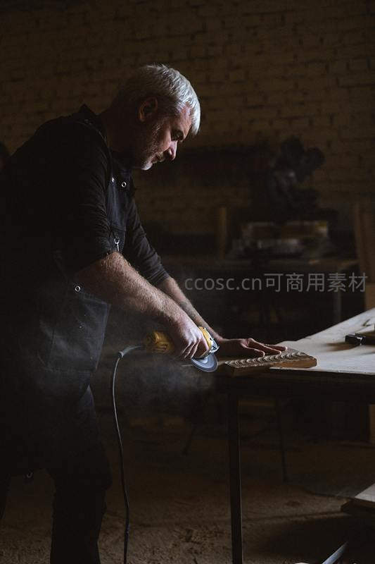 工匠专注打磨木料，尘埃在光束中飞舞