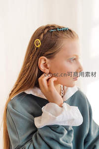 少女侧颜凝望远方，发间夹着彩色发卡