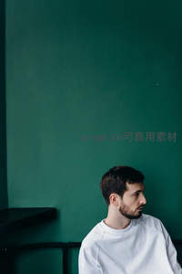 绿墙前的沉思男子