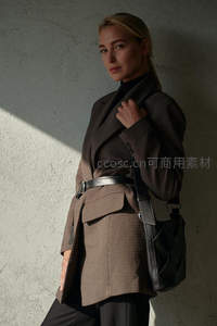 时尚女性倚墙展示格纹西装外套