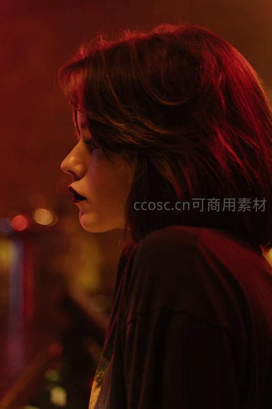 红光映照下女子侧颜静谧
