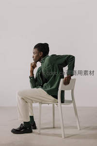 绿衣青年坐椅沉思姿态