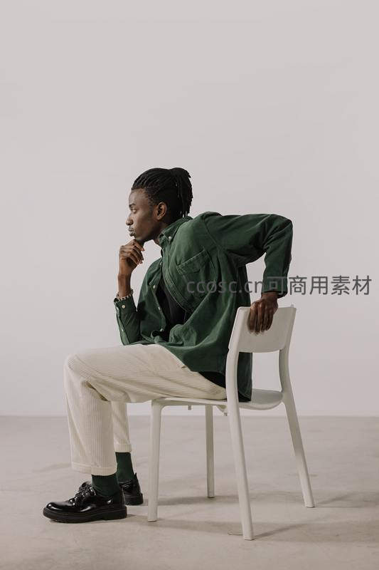 绿衣青年坐椅沉思姿态