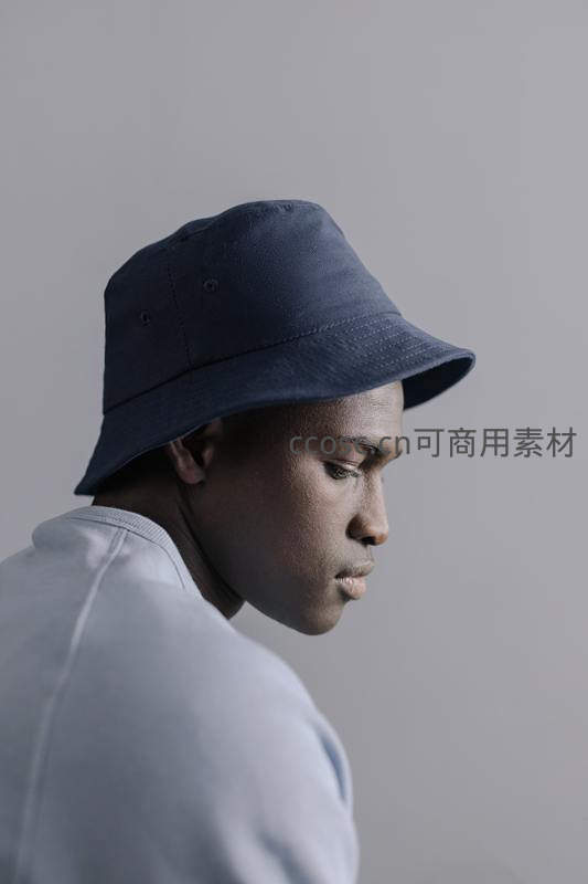 蓝帽青年低头沉静侧影