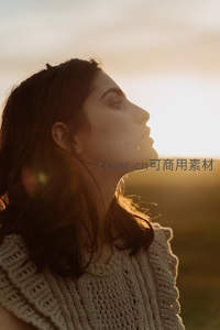 夕阳下闭目沉思的女子侧影