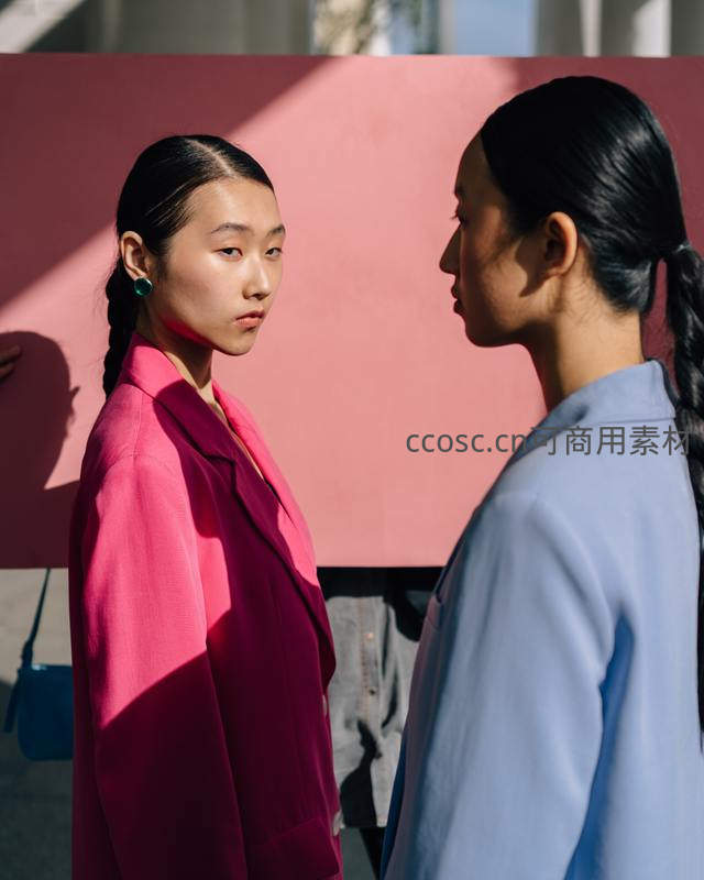 粉墙前双女对视瞬间