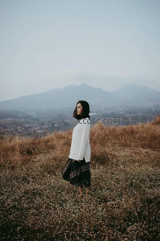 山野花丛中，白衣女子凝望远方