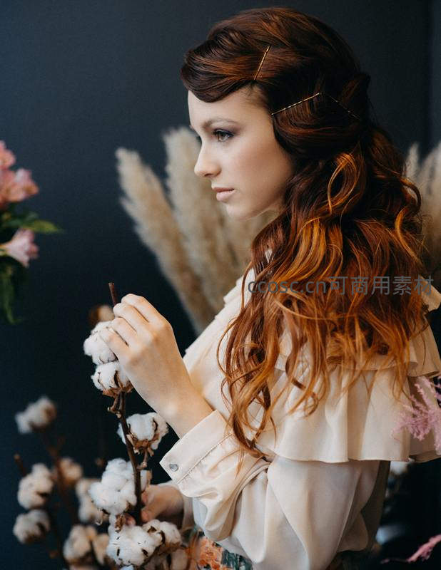 红发女子轻抚棉花的温柔瞬间