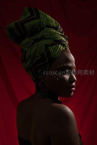 红幕前沉思的头巾女子