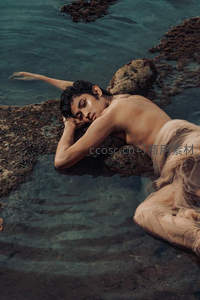 男子水中倚石如雕塑般静谧