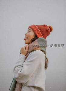 雪中女子戴红帽吐舌微笑