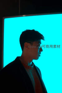 男子侧脸映衬蓝色背景屏显科技感