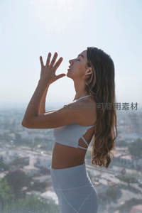 女子阳台迎光伸展，享受宁静清晨时光