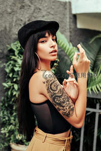 纹身女郎戴帽回眸，街头艺术感爆棚