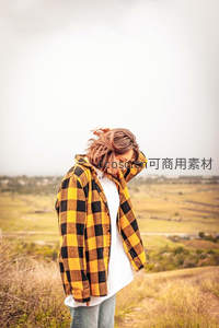 山丘之上，少女整理微乱发丝