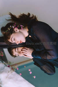 花环少女俯身轻抚镜中倒影