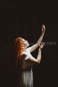 暗室中红发少女伸手触碰光束