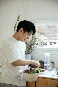 厨房里精心准备沙拉的青年