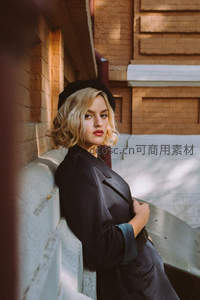 砖墙光影中，金发女郎优雅回眸凝视