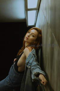 红发女郎靠墙展现时尚魅力