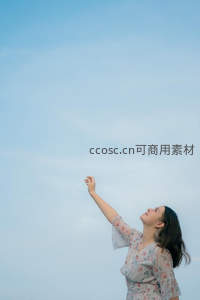 女子伸手触摸蓝天