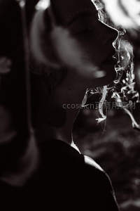 黑白光影中女子吐烟雾侧脸艺术照