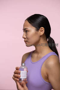 紫衣女子手持透明瓶装护肤品侧颜特写