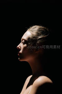 暗背景下金色发丝女子侧脸柔光写真