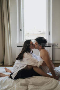 窗边床上的情侣亲吻
