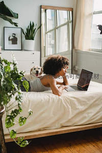 女子卧床使用笔记本电脑工作场景