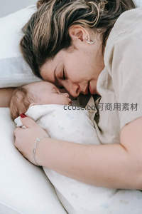 母亲温柔怀抱熟睡婴儿