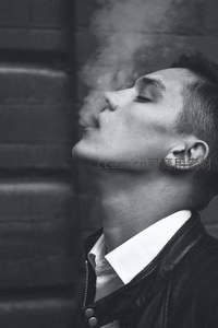 黑白光影中仰望吐烟的男子