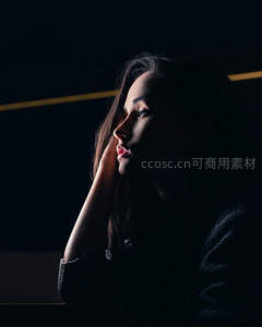 暗调光影中的沉思女子侧颜