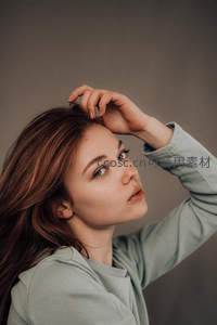 绿衣少女轻抚秀发，眼神清澈自然灵动