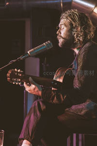 卷发歌手闭眼弹唱吉他