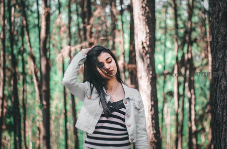 林间少女轻抚秀发眼神迷离悠然