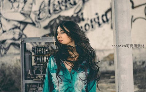 街头涂鸦背景下的长发女子侧影
