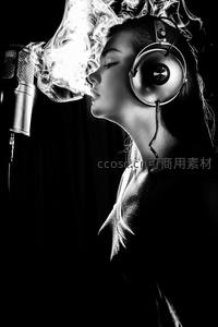 耳机少女对着麦克风吐烟圈，黑白光影充满音乐感