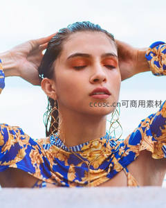 海边艳妆女子闭目享受阳光