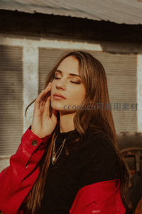 红衣女子在暖阳中闭目养神