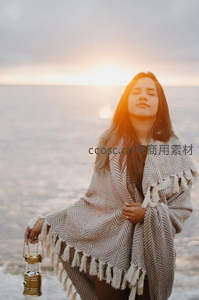 海边日落时分的温暖女子剪影