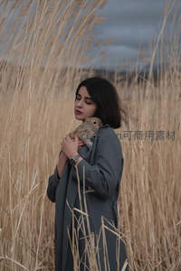 芦苇荡中女子温柔怀抱小兔