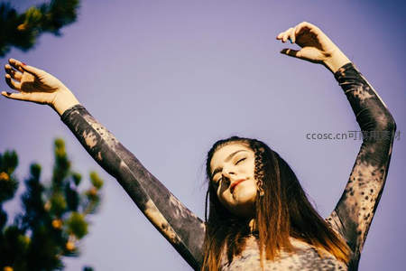 蓝天之下女子舒展双臂享受阳光
