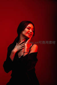 红光中的优雅女子，黑色礼服尽显神秘魅力