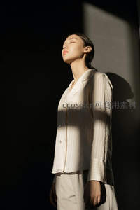 光影交错的优雅身影，白衣女子静享阳光