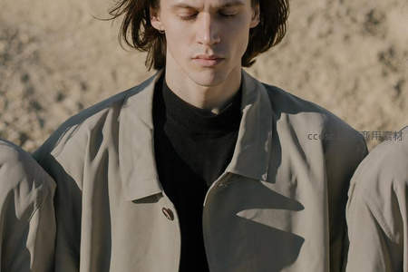 长发青年在沙地背景下沉静冥想