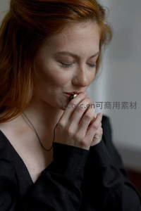 红发女子轻咬手指陷入沉思